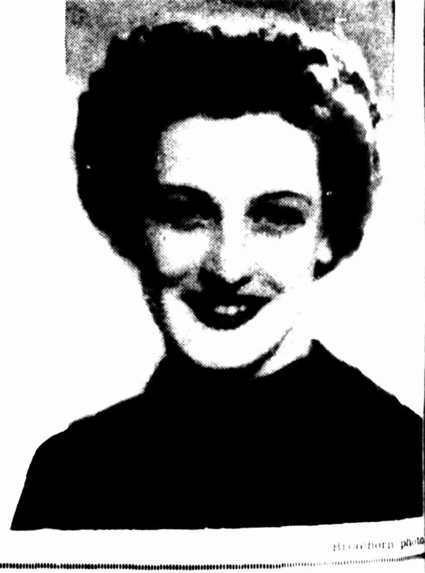 A newspaper portrait of a smiling young woman with thick dark hair waved up off her forehead, in a dark high-necked top.
